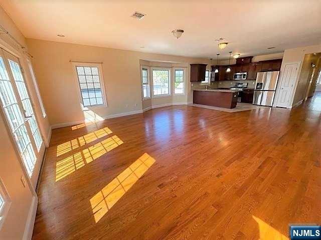 315 Frank E Rodgers Boulevard North, Unit 3 Harrison, NJ 07029 - Photo 4 of 18 a view of empty room with wooden floor and fan