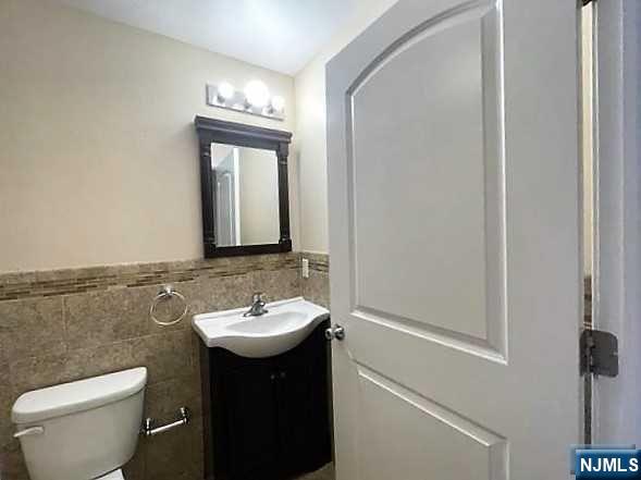 315 Frank E Rodgers Boulevard North, Unit 3 Harrison, NJ 07029 - Photo 7 of 18 a bathroom with a toilet sink and mirror