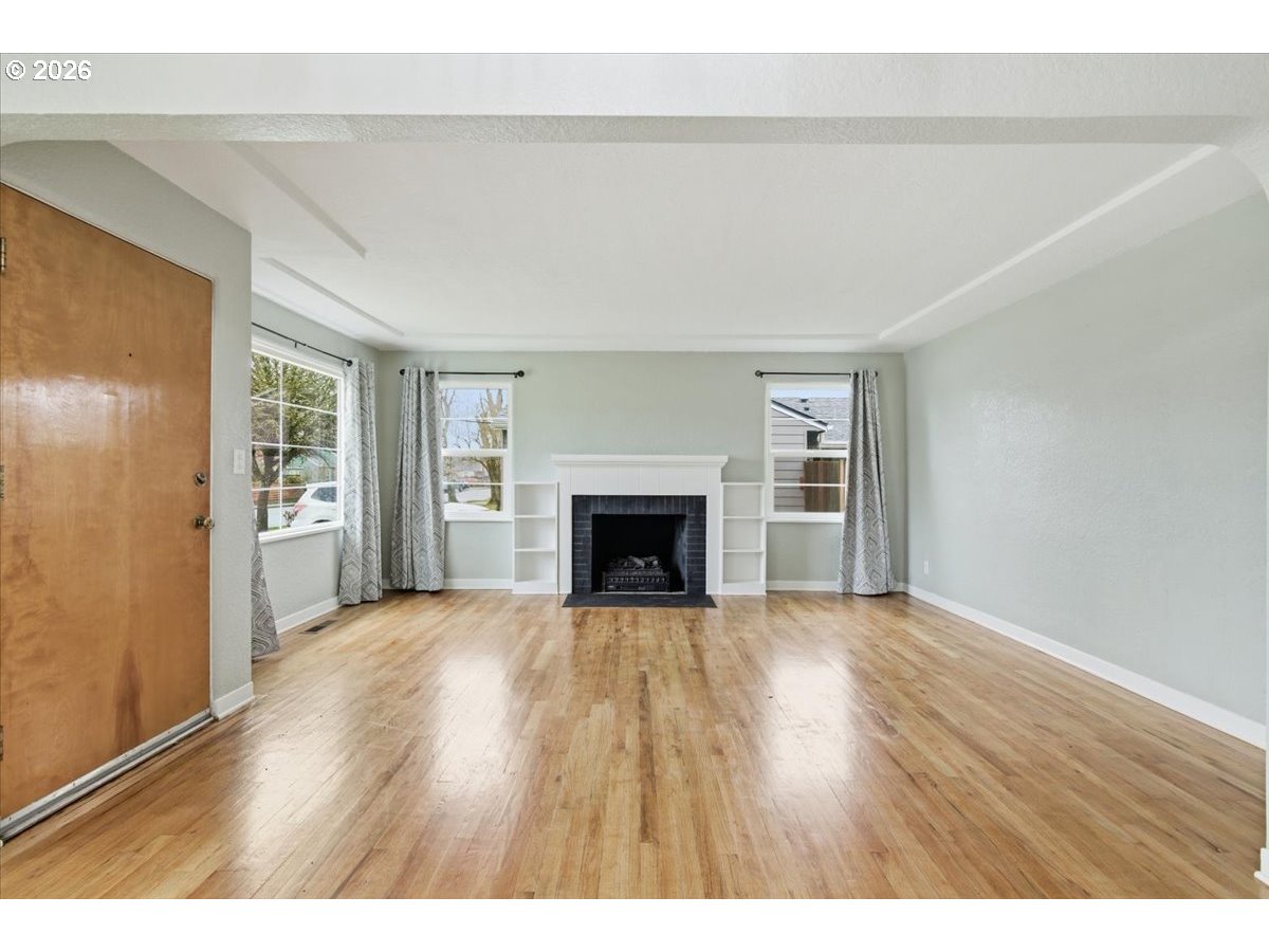 1084 24th Street Northeast Salem, OR 97301 - Photo 6 of 30 a view of an empty room with wooden floor and a window