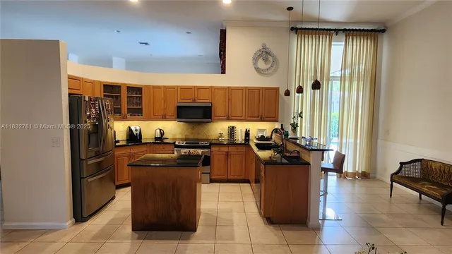 a kitchen with a refrigerator and a stove top oven