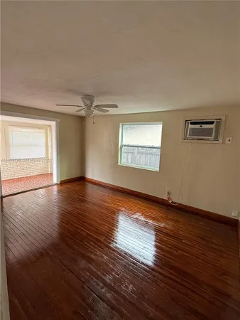 a view of a livingroom with wooden floor and window