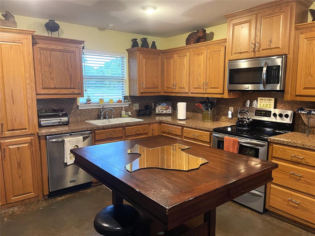 151 Lcr Cedar C3 Mexia, TX 76667 - Photo 7 of 28 a kitchen with stainless steel appliances a sink a microwave a stove and refrigerator