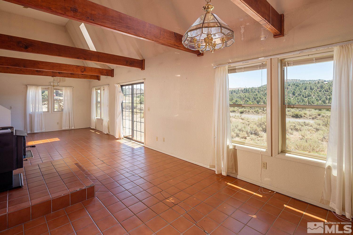 21400 Graves Road Reno, NV 89521 - Photo 3 of 21 a view of an empty room with wooden floor and a window