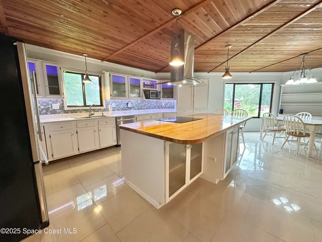 a view of a kitchen with kitchen island a counter tops pace a sink and appliances