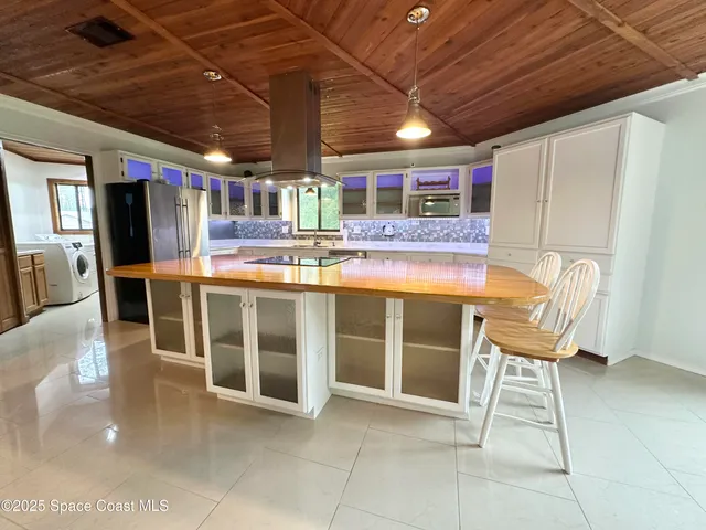 a view of a kitchen with a dining table chairs and wooden floor