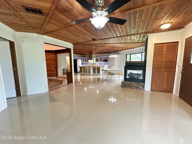 a view of a hall with a dining table chairs and a chandelier