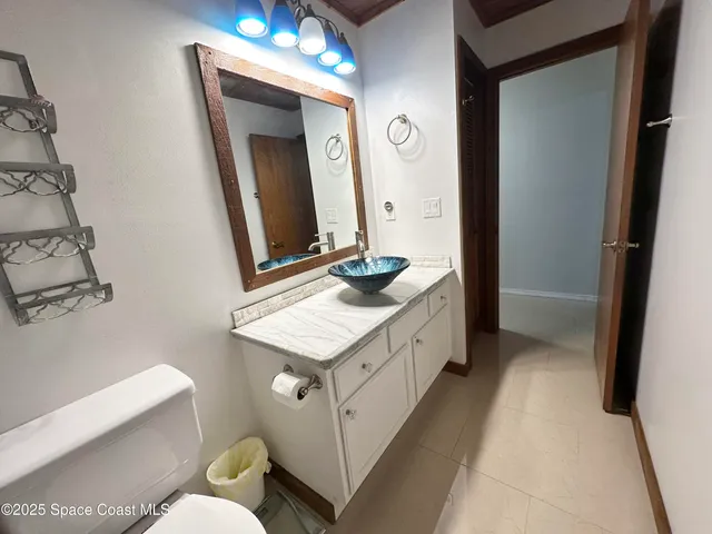 a bathroom with a granite countertop sink a toilet and a mirror
