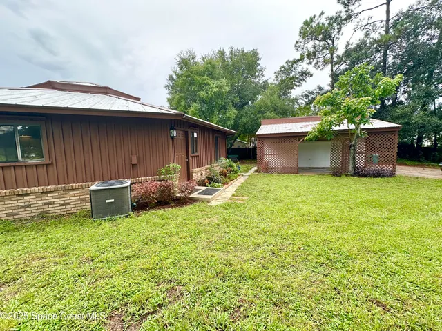 a view of a house with a yard and sitting area