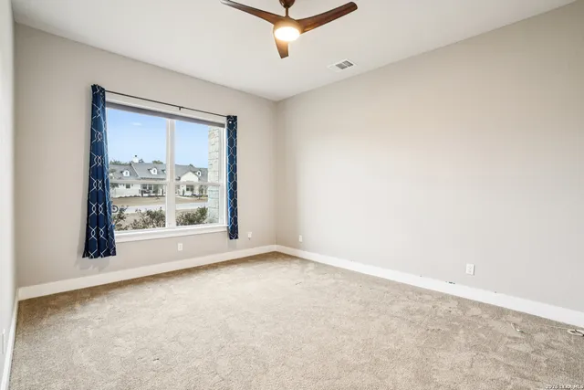 an empty room with a chandelier fan