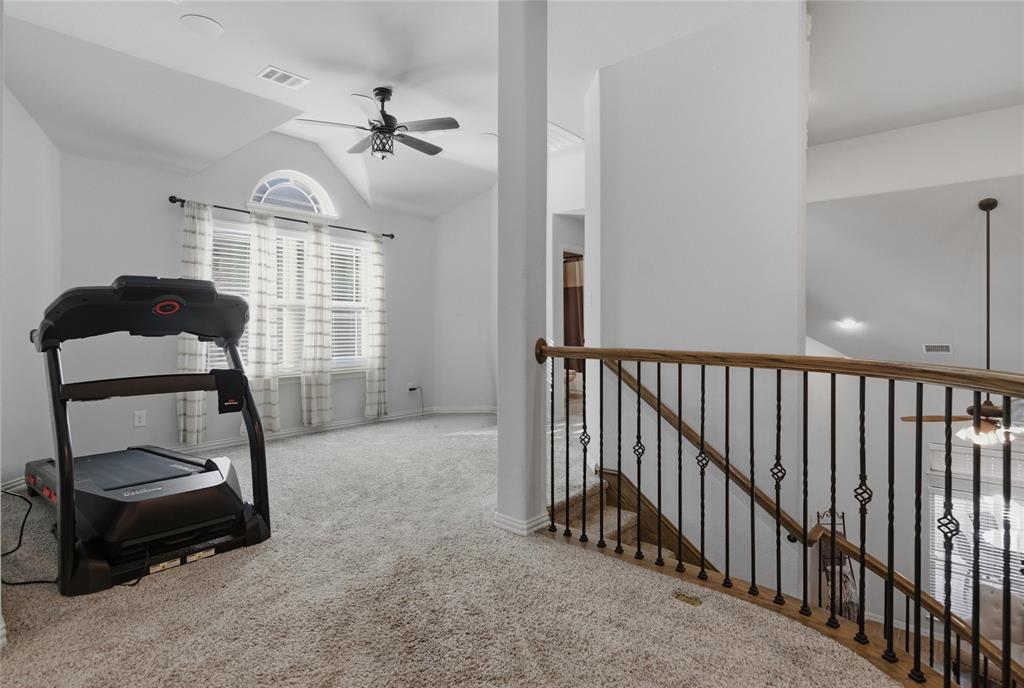 464 LeTara Ranch Drive Haslet, TX 76052 - Photo 25 of 37 Carpeted upper-level landing featuring a wood-finish handrail with wrought iron balusters and a half-arch window