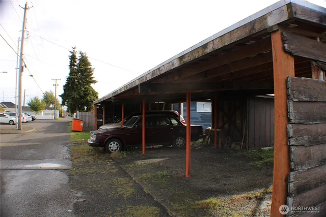 a view of a house that has a car parked beside a road