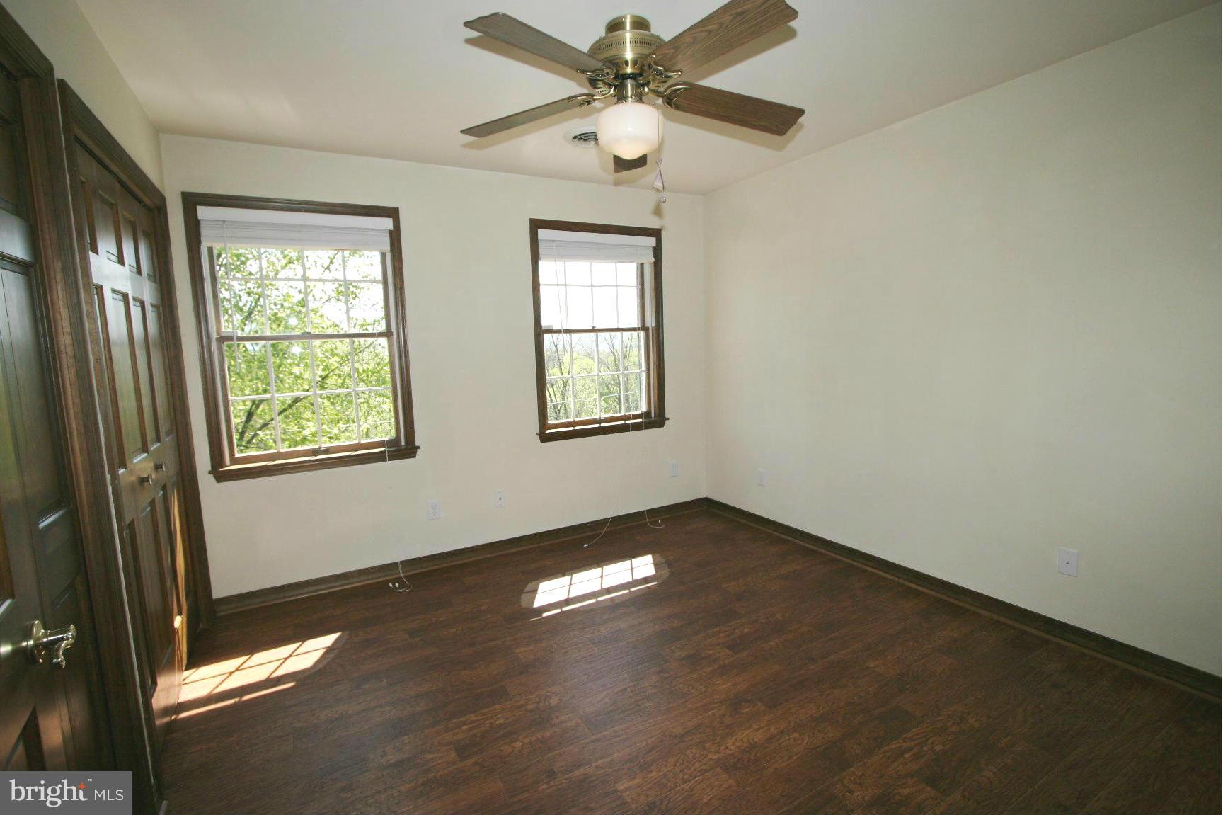 20834 Netz Road Boonsboro, MD 21713 - Photo 11 of 30 an empty room with wooden floor fan and windows