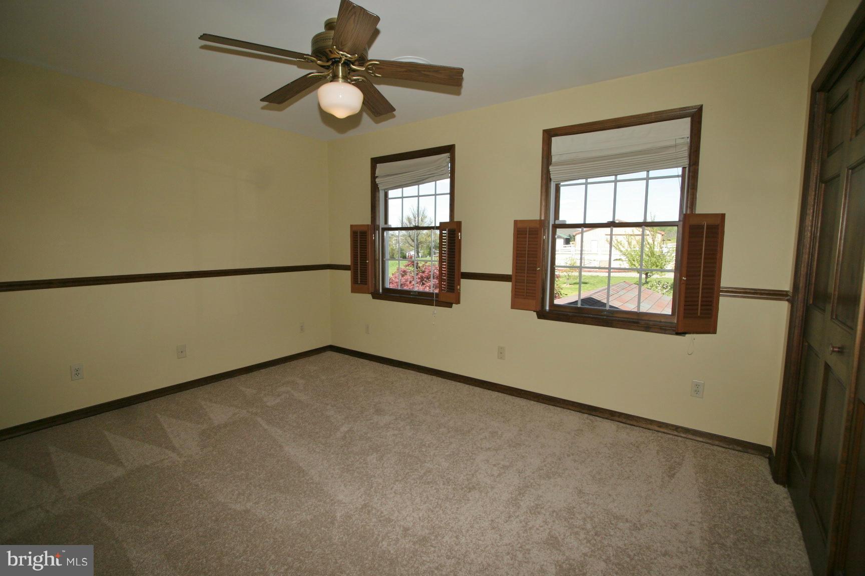 20834 Netz Road Boonsboro, MD 21713 - Photo 12 of 30 an empty room with chandelier fan and windows