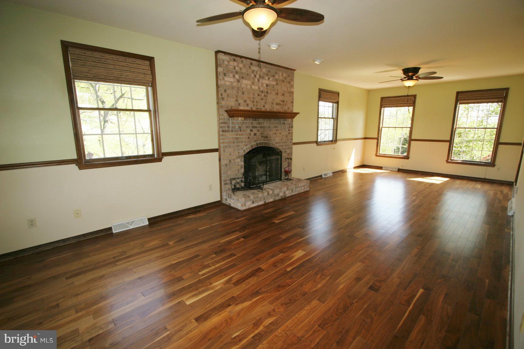20834 Netz Road Boonsboro, MD 21713 - Photo 5 of 30 a view of an empty room with wooden floor fireplace and a window