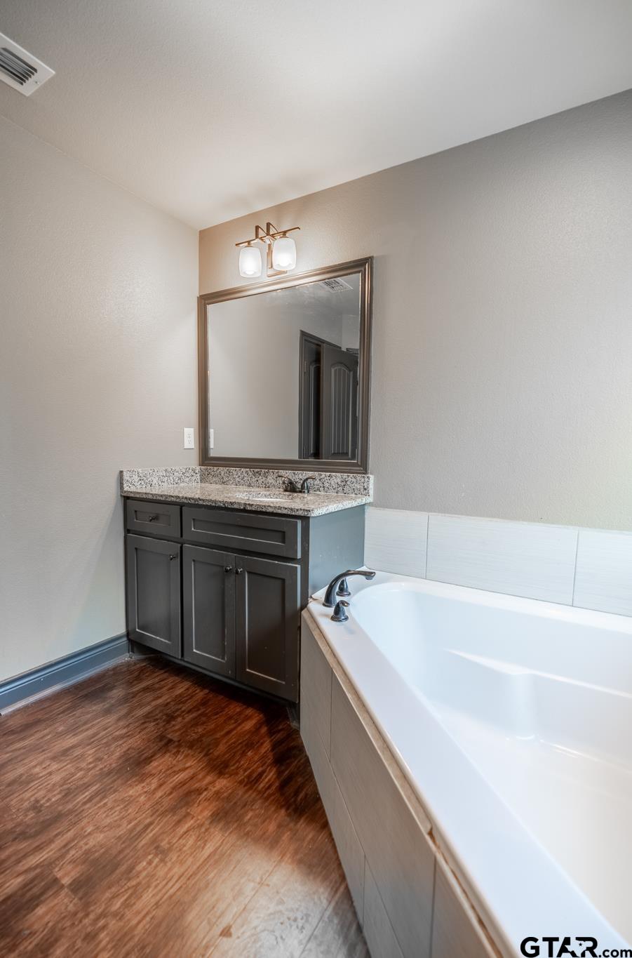 14062 Bent Trail Tyler, TX 75707 - Photo 28 of 46 a spacious bathroom with a tub double vanity sink and mirror
