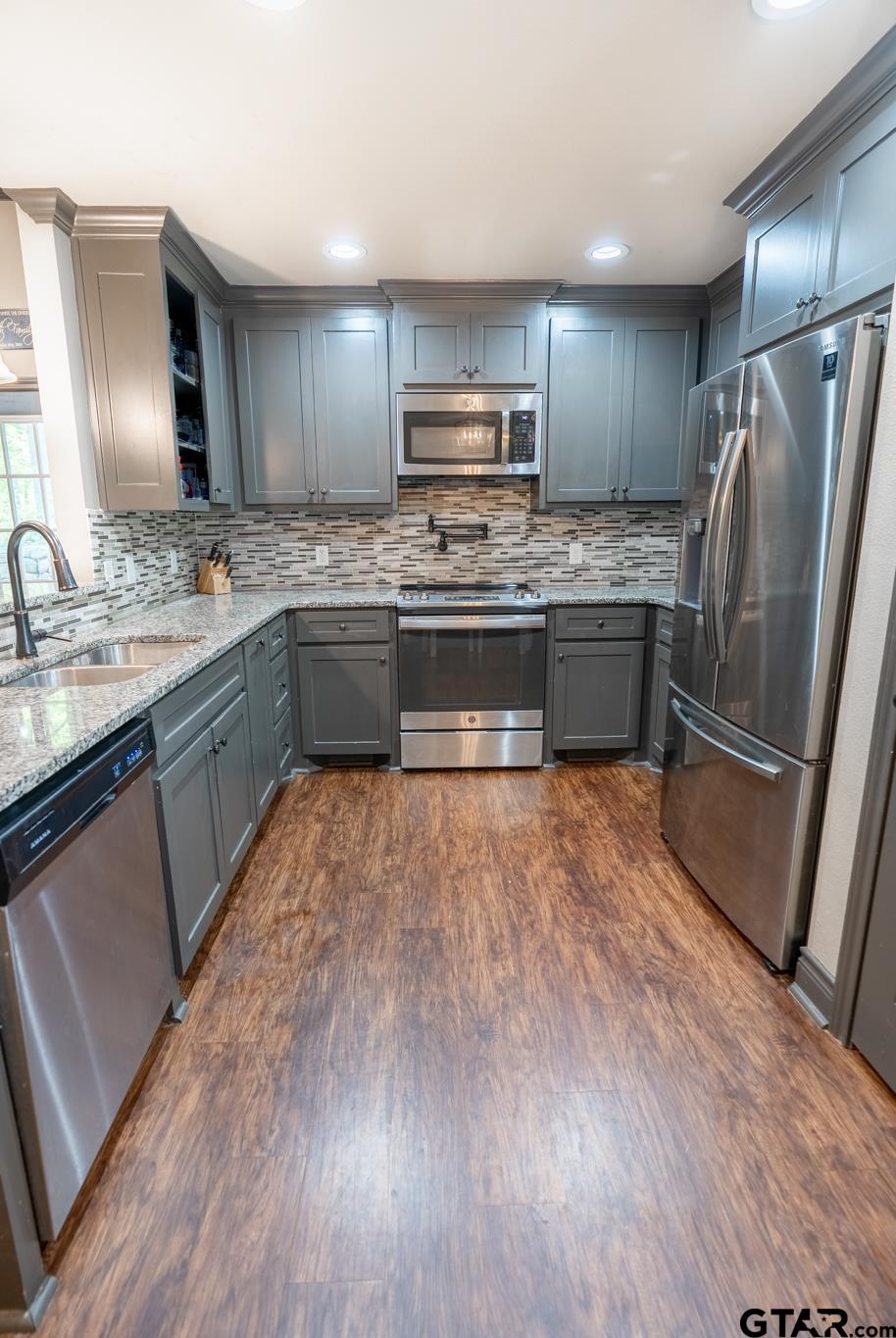 14062 Bent Trail Tyler, TX 75707 - Photo 8 of 46 a kitchen with stainless steel appliances wooden floors and wooden cabinets