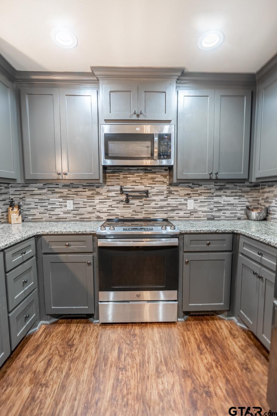 14062 Bent Trail Tyler, TX 75707 - Photo 9 of 46 a kitchen with stainless steel appliances granite countertop a sink stove and cabinets