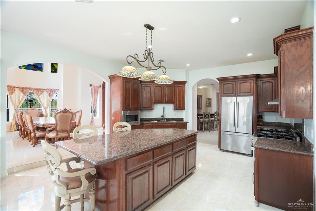 508 El Paisano Road Rio Grande City, TX 78582 - Photo 13 of 40 a kitchen with stainless steel appliances granite countertop a stove refrigerator and cabinets