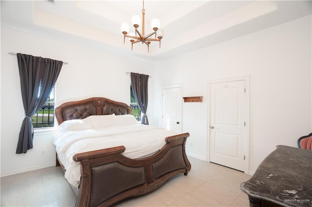 508 El Paisano Road Rio Grande City, TX 78582 - Photo 19 of 40 a bedroom with a bed and a chandelier