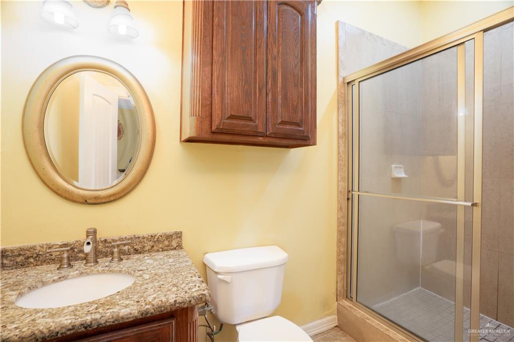 508 El Paisano Road Rio Grande City, TX 78582 - Photo 32 of 40 a bathroom with a granite countertop toilet sink and a mirror