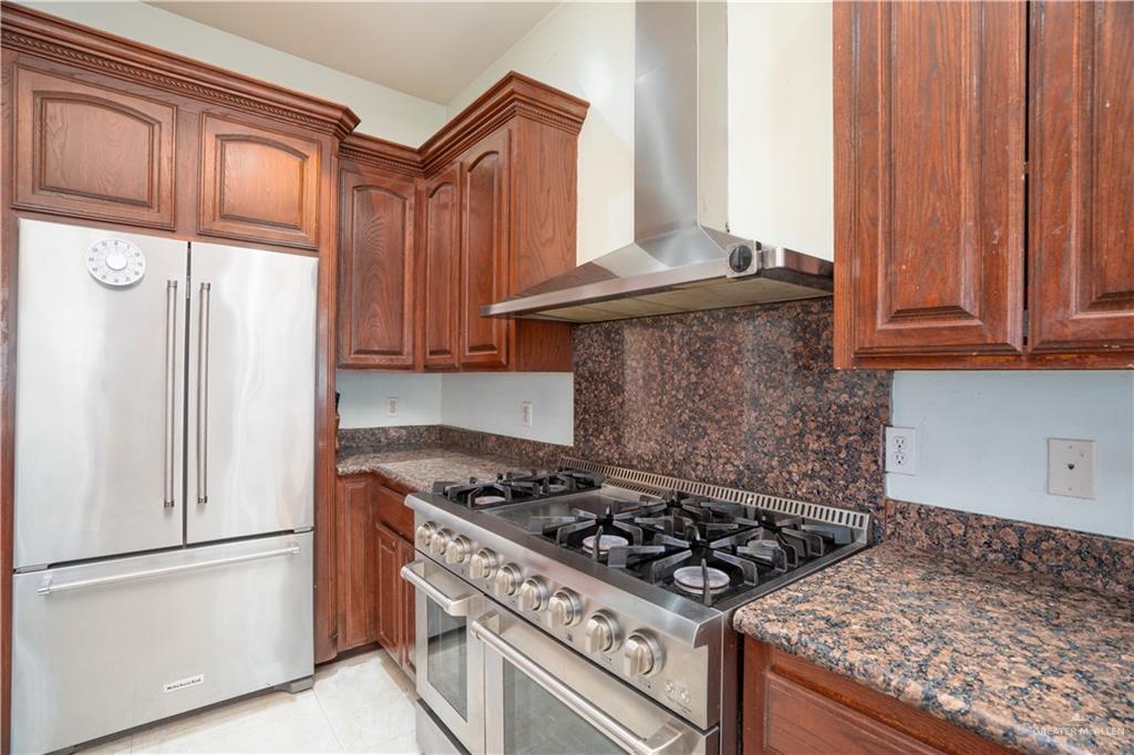 508 El Paisano Road Rio Grande City, TX 78582 - Photo 34 of 40 a kitchen with granite countertop a stove and a refrigerator