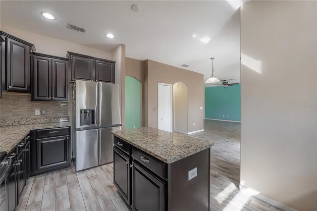 a kitchen with kitchen island granite countertop a sink and stainless steel appliances