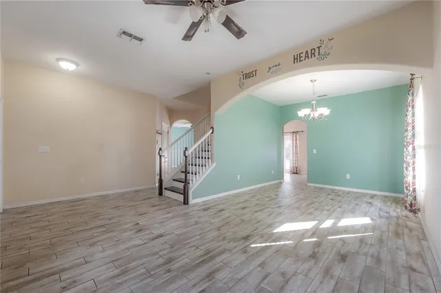 a view of a livingroom with a ceiling fan and wooden floor