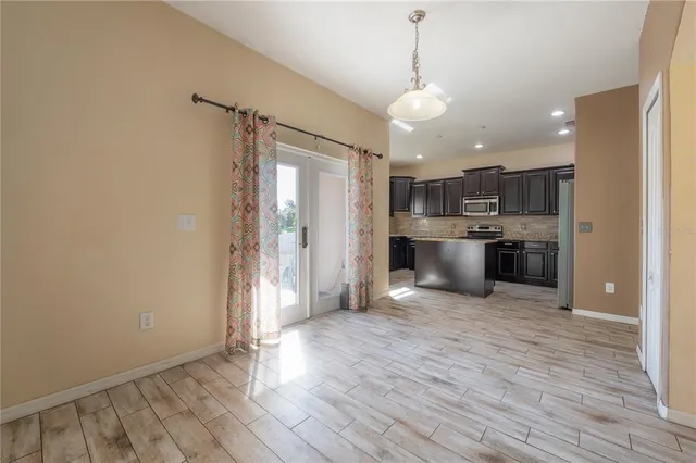 a view of a kitchen with a refrigerator and a stove top oven