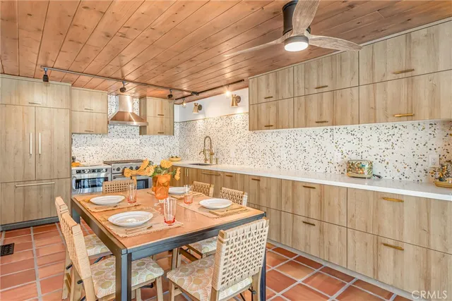 a dining room with stainless steel appliances granite countertop a sink and cabinets