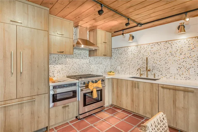 a kitchen with stainless steel appliances a stove a sink and a refrigerator