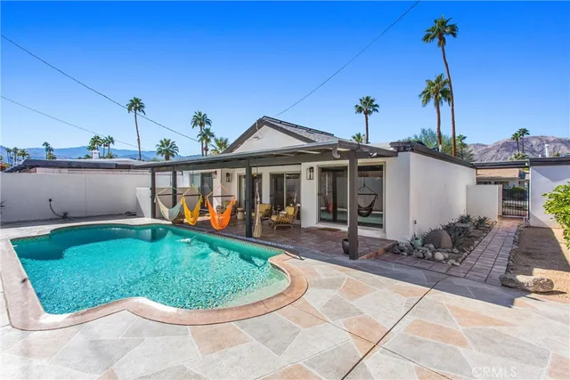 a view of a house with backyard sitting area and lake view
