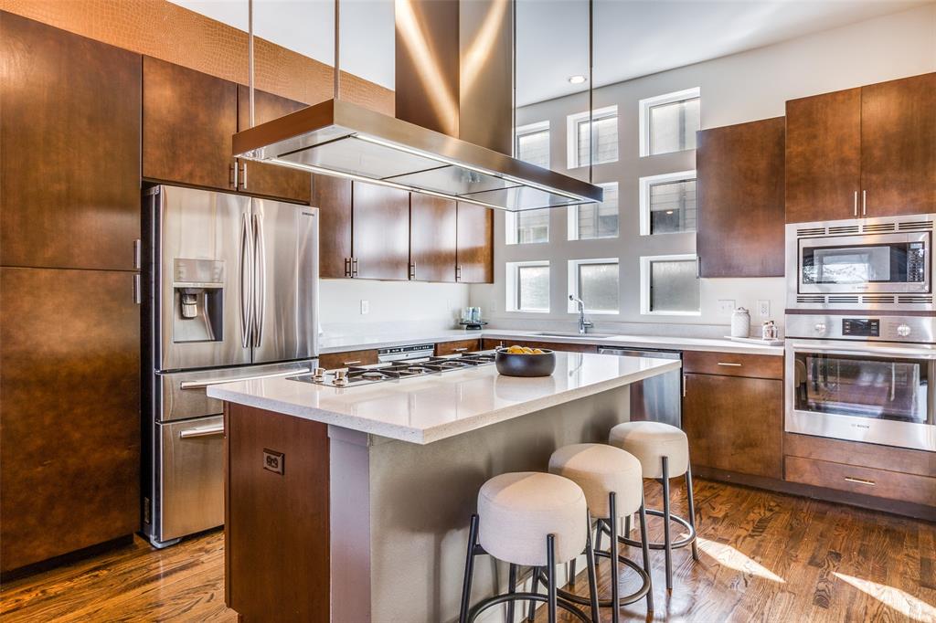 4610 Steel Street Dallas, TX 75219 - Photo 12 of 18 a kitchen with stainless steel appliances granite countertop a sink a stove and chairs