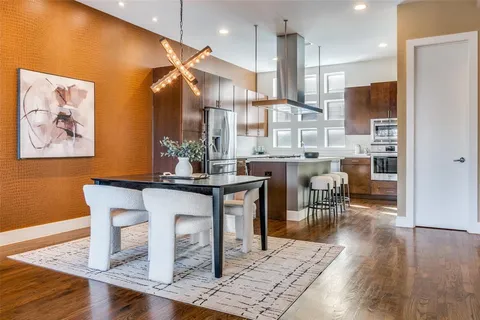 a room with stainless steel appliances kitchen island granite countertop furniture and a wooden floor