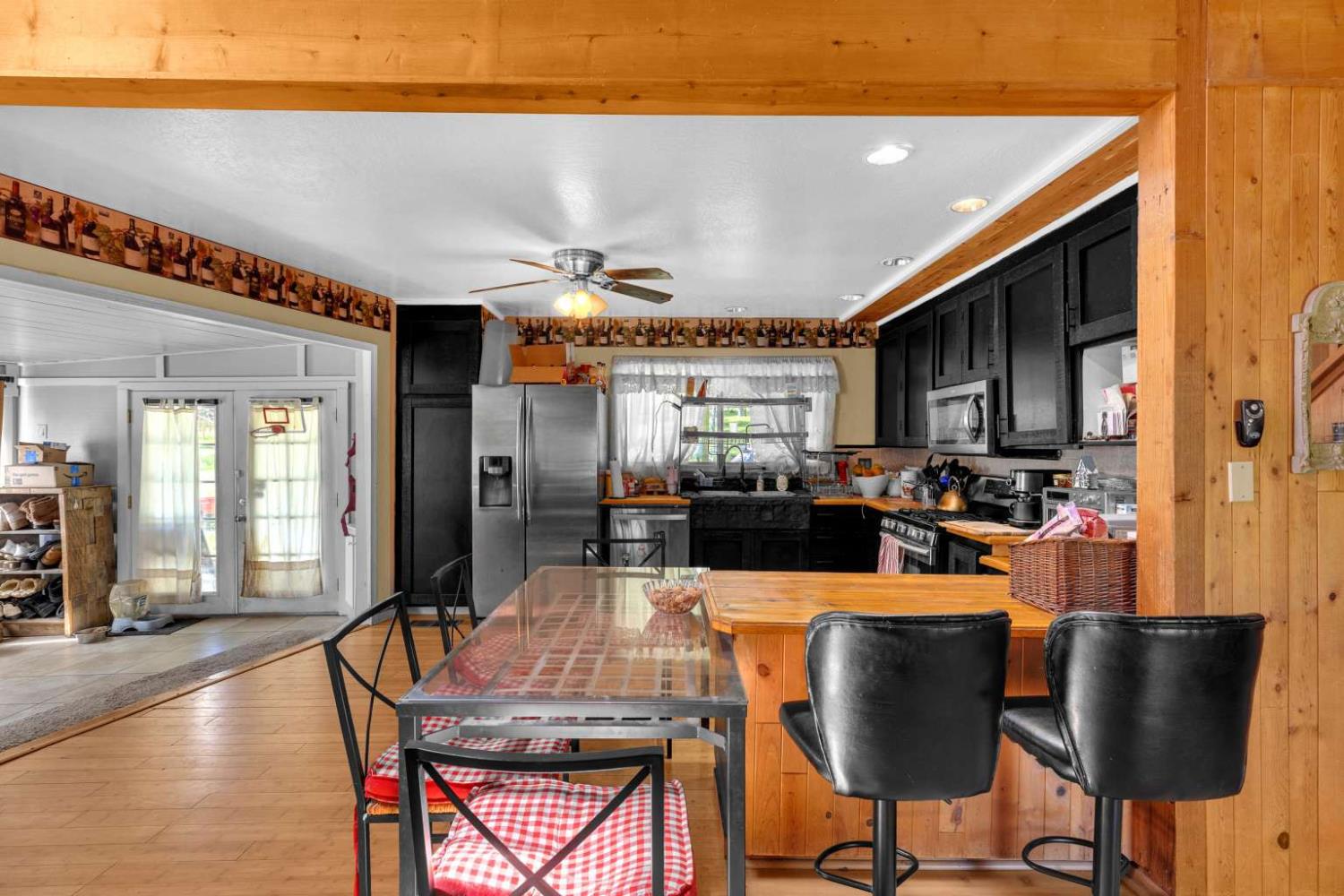 13489 Yorkshire Road Groveland, CA 95321 - Photo 12 of 35 a dining hall with stainless steel appliances a dining table and chairs with wooden floor