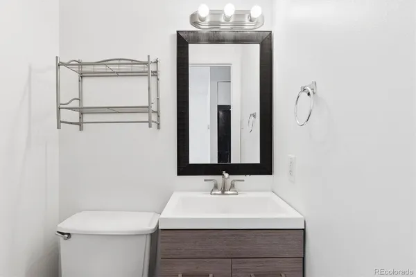 a bathroom with a sink a toilet and mirror