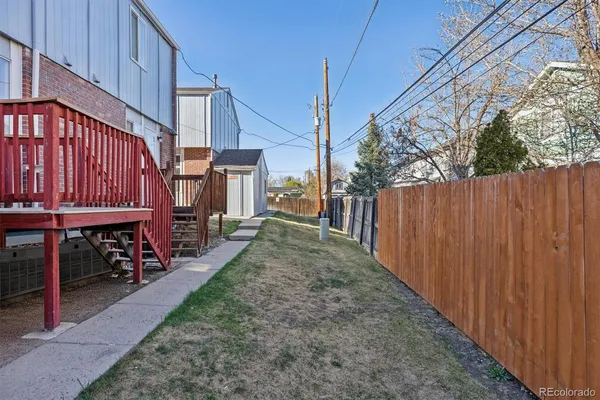 a view of a backyard with sitting area and wooden fence