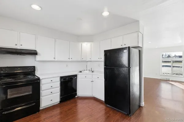 a kitchen with a refrigerator stove and wooden cabinets
