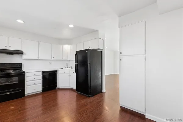 a kitchen with a refrigerator and a stove top oven