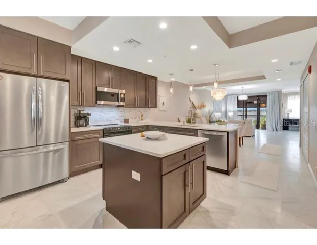 a kitchen with kitchen island a sink stainless steel appliances and cabinets