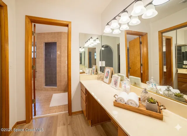 a bathroom with a sink a large mirror and a shower