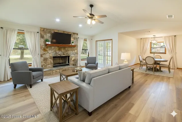 a living room with furniture fireplace and a large window