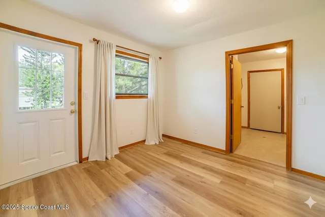 an empty room with wooden floor and a window