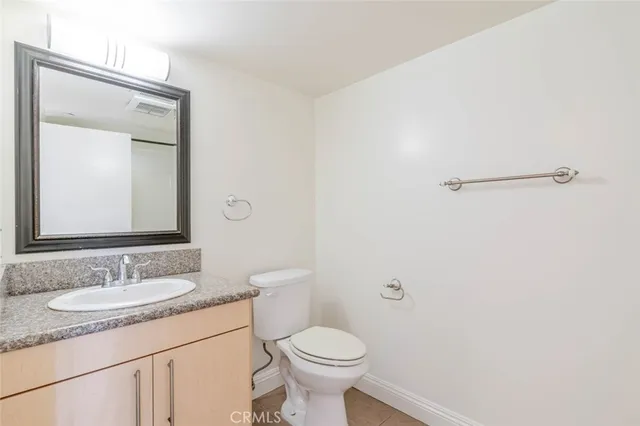 a bathroom with a toilet sink vanity and mirror