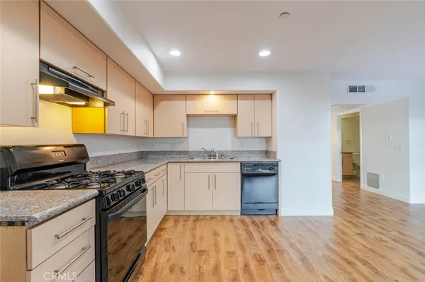 a kitchen with granite countertop a stove a sink and a microwave