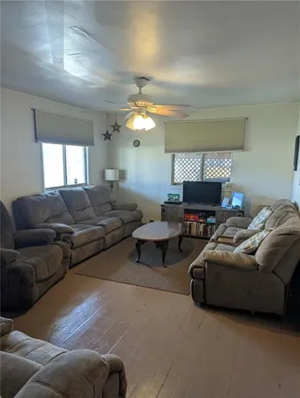 a living room with furniture a fireplace and a chandelier