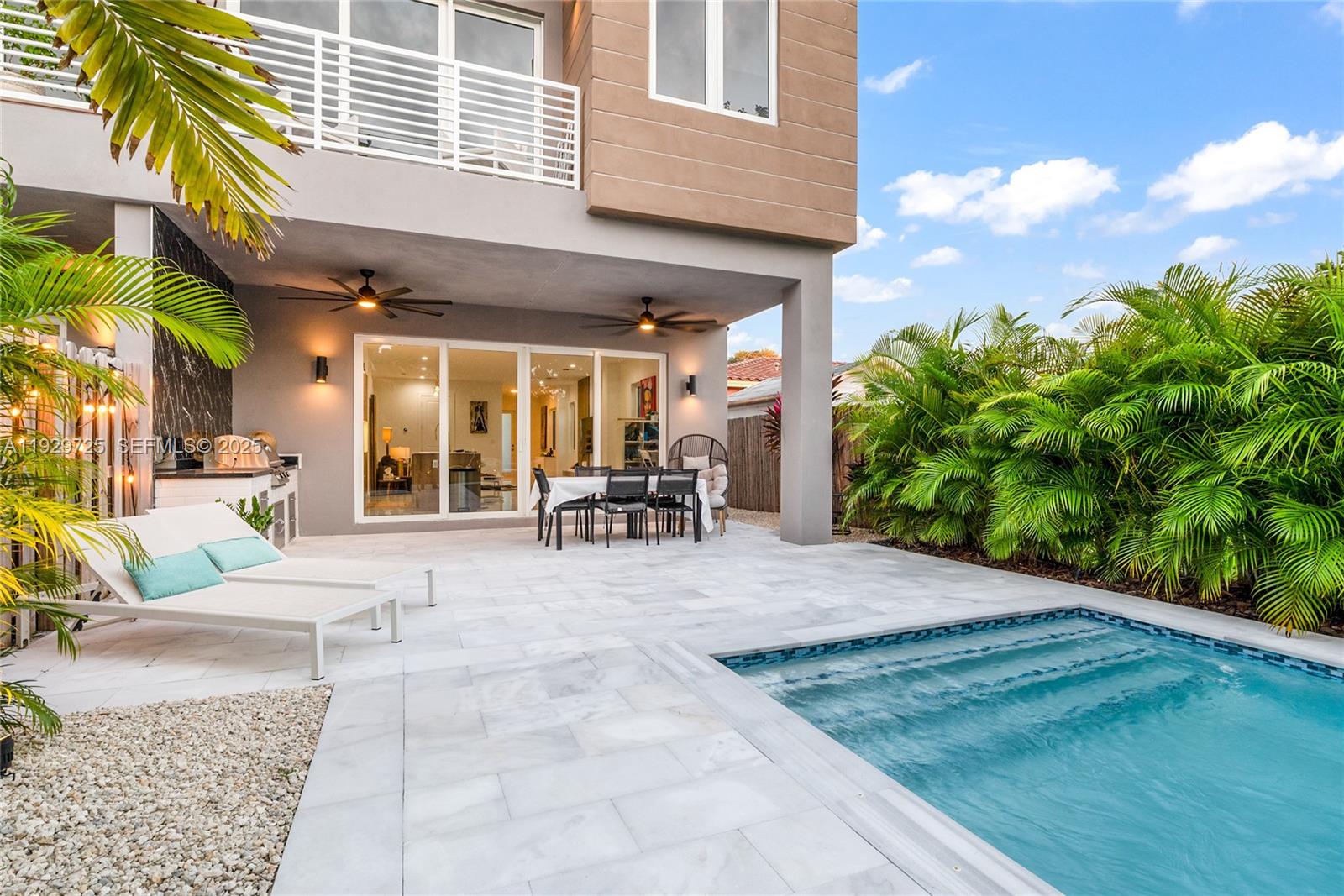 2756 Southwest 34th Court, Unit B Miami, FL 33133 - Photo 26 of 33 a view of a patio with dining table and chairs with plants and palm trees