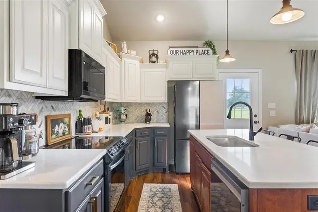 a kitchen with stainless steel appliances granite countertop a sink a stove and a refrigerator