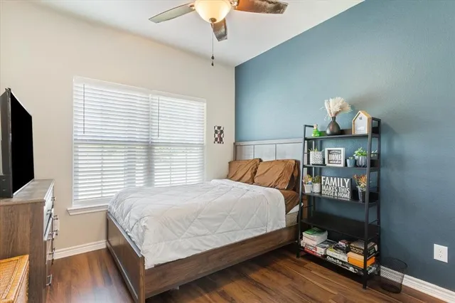 a bedroom with a bed and a flat tv screen on dresser