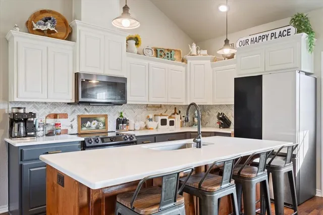 a kitchen with stainless steel appliances a table chairs and a refrigerator