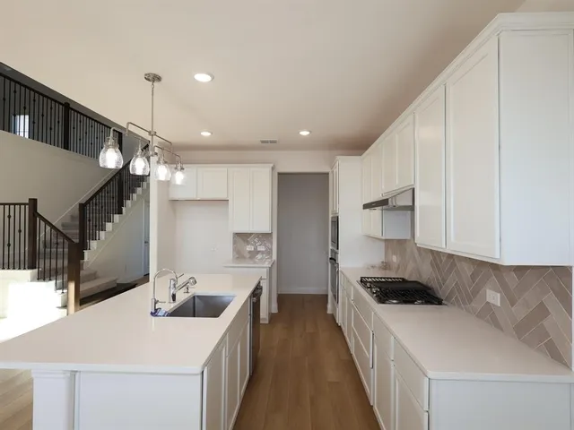 a kitchen with a sink a stove and chairs